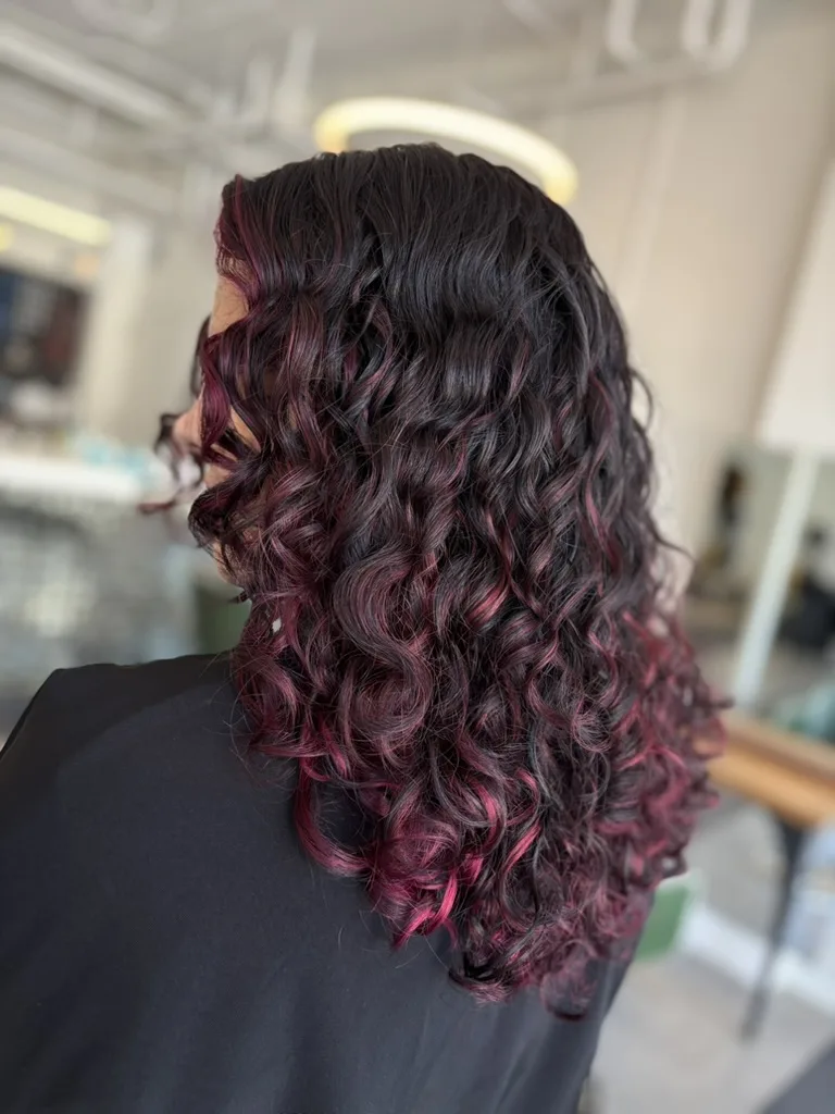 Defined curls with burgundy highlights, back view